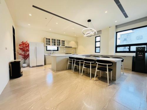 Una cocina con una gran isla con taburetes de bar. en Mu Yue Homestay, en Dongshan