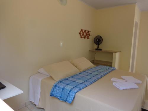 a small bedroom with a bed with towels on it at Pousada Por-do-Sol in Conceição do Mato Dentro