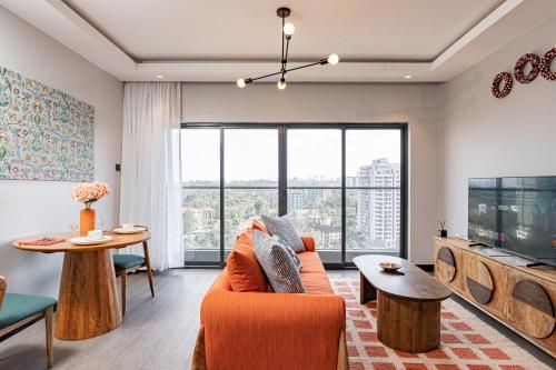 ナイロビにあるEscada Studio & 2-bedroom, Rooftop Swimming Pool, Gym, Workspace, Wonderiss Homes Westland Livingのソファとテレビのあるリビングルーム