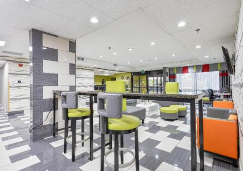 a lobby with a bar with yellow and gray stools at Quality Inn Prattville I-65 in Prattville