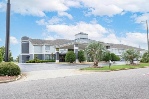 a large white building with palm trees in front of it at Quality Inn Prattville I-65 in Prattville