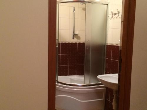 een badkamer met een douche, een toilet en een wastafel bij Olimp Soup&Bed in Ivano-Frankovo