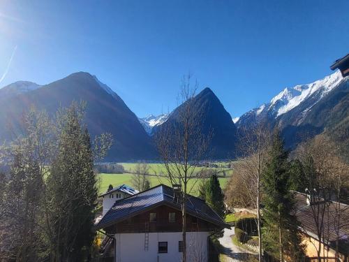 a house with mountains in the background at Apartment in Hohe Tauern with Mountain Views in Neukirchen am Großvenediger