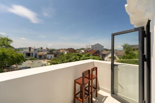 a balcony with two chairs looking out at the city at Sanh Homestay in Hue