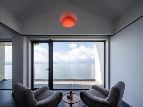 a room with two chairs and a large window at Mont XIX Villa - Panoramic Sea & Mountain View in Dali Airport