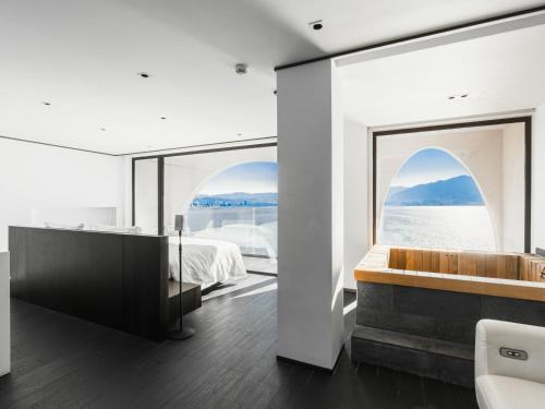 a bedroom with a tub and a large window at Mont XIX Villa - Panoramic Sea & Mountain View in Dali Airport