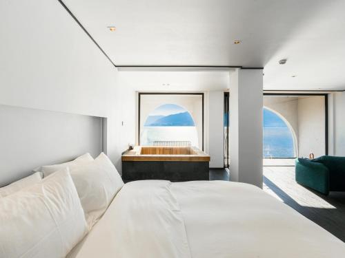 a bedroom with a large bed and a tub at Mont XIX Villa - Panoramic Sea & Mountain View in Dali Airport