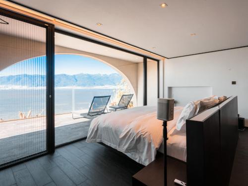 a bedroom with a large bed and a large window at Mont XIX Villa - Panoramic Sea & Mountain View in Dali Airport
