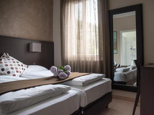 una camera d'albergo con due letti e uno specchio di Locanda Del Conventino a Lugano