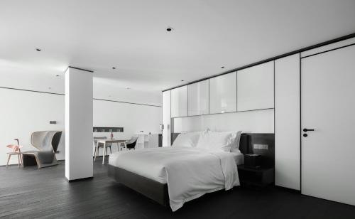 a bedroom with a large white bed and a table at Mont XIX Villa - Panoramic Sea & Mountain View in Dali Airport
