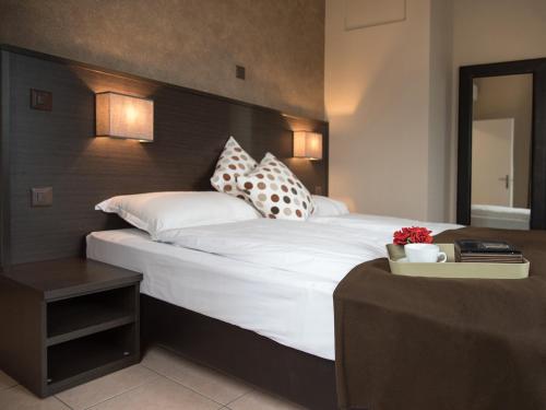 a bedroom with a large bed with white sheets and pillows at Locanda Del Conventino in Lugano