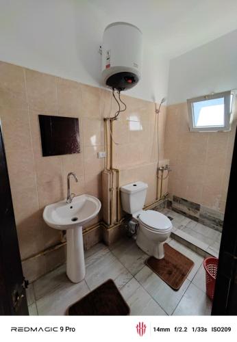 a bathroom with a toilet and a sink at فيلا علي in Sheikh Zayed