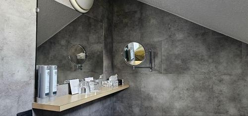a bathroom with a mirror and a shelf with cosmetics at Mountains Hotel in Seefeld in Tirol