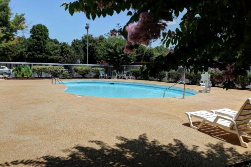 a swimming pool with two lounge chairs in a yard at Country Inn & Suites by Radisson, Charlotte I-85 Airport, NC in Charlotte