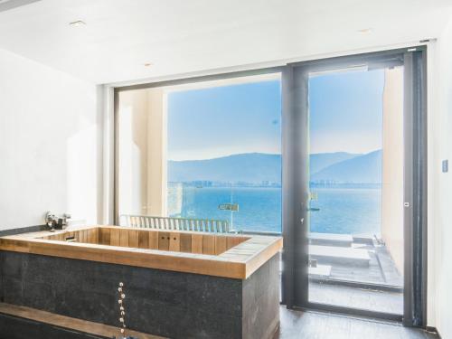 a large bathroom with a tub with a view of the water at Mont XIX Villa - Panoramic Sea & Mountain View in Dali Airport
