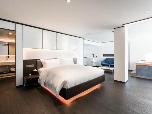 a bedroom with a large bed and a bathroom at Mont XIX Villa - Panoramic Sea & Mountain View in Dali Airport