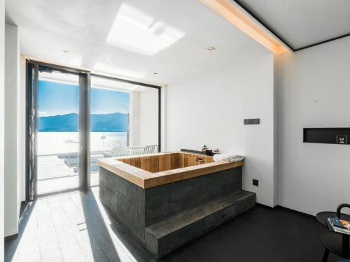 a bathroom with a large wooden tub with a large window at Mont XIX Villa - Panoramic Sea & Mountain View in Dali Airport