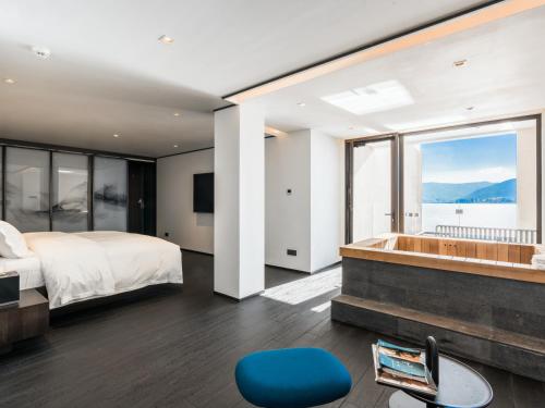 a bedroom with a large bed and a tub at Mont XIX Villa - Panoramic Sea & Mountain View in Dali Airport