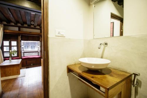 a bathroom with a sink and a mirror at The Newari dream in Old Patan-high ceiling & charm in Pātan