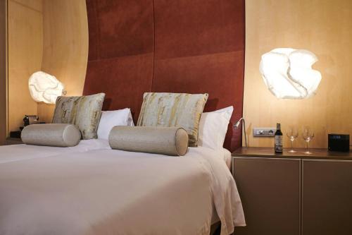 a bedroom with a white bed with two pillows at Hotel Marqués de Riscal, a Luxury Collection Hotel, Elciego in Elciego