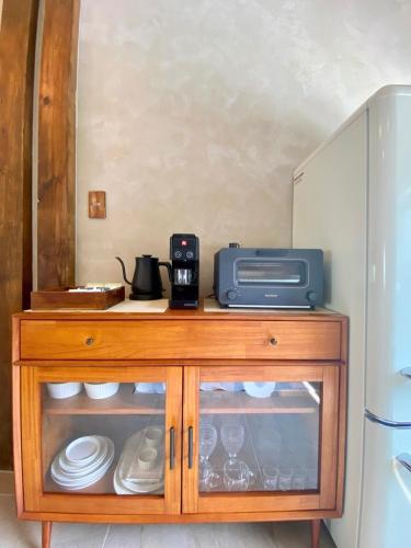a wooden cabinet with a microwave and plates on it at 오를 Orle in Kama-ri