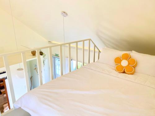 a white bed with a flower shaped pillow on it at 오를 Orle in Kama-ri