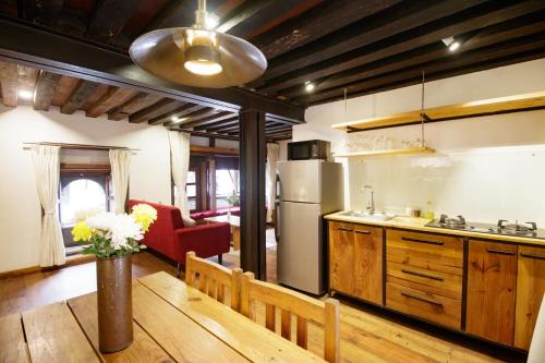 a kitchen with a refrigerator and a table and a couch at The Newari dream in Old Patan-high ceiling & charm in Pātan