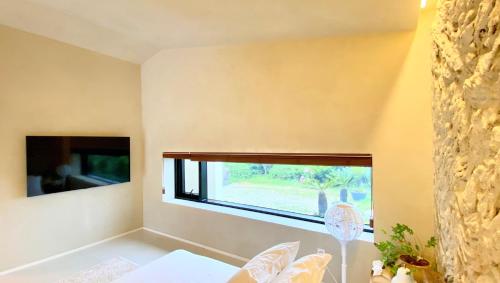 a bedroom with a large window in the corner of the room at 오를 Orle in Kama-ri