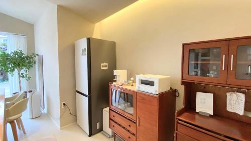 a kitchen with a refrigerator and a table with a microwave at 오를 Orle in Kama-ri