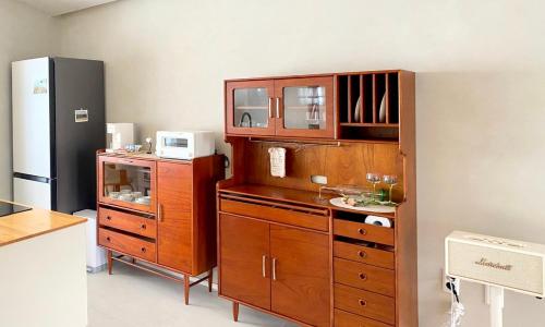 a kitchen with a large wooden cabinet with a microwave at 오를 Orle in Kama-ri