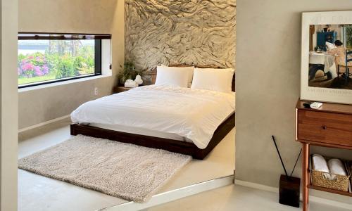 a bedroom with a bed with white sheets and a window at 오를 Orle in Kama-ri