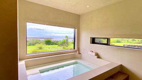 a large bath tub in a room with a window at 오를 Orle in Kama-ri