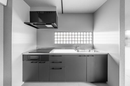 a kitchen with a sink and a stove at SnowGarden YIG STAY in Furano