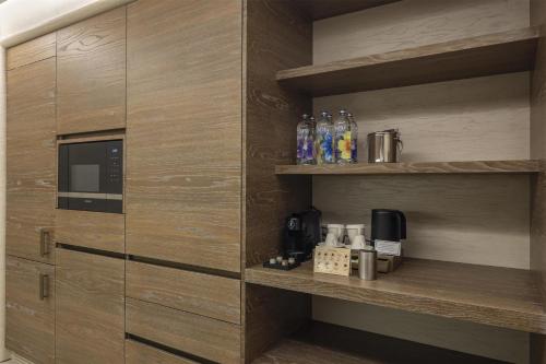 a kitchen with wooden cabinets with a microwave at Hilton Istanbul Bosphorus in Istanbul