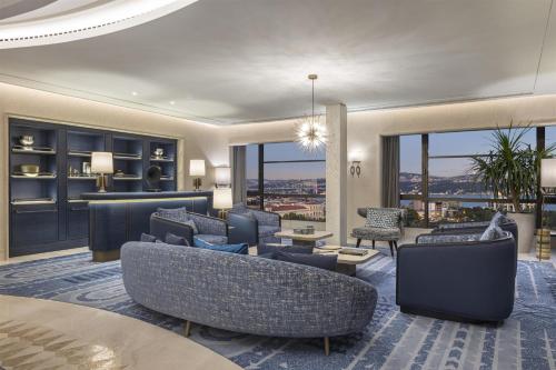 a living room with couches and chairs and windows at Hilton Istanbul Bosphorus in Istanbul