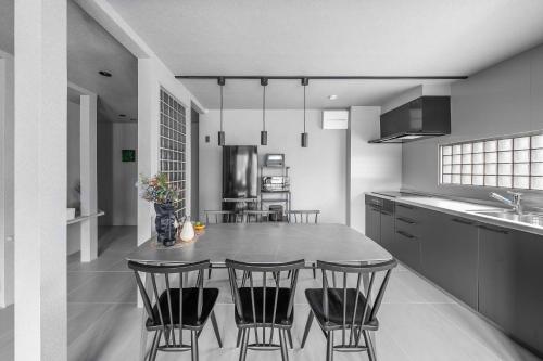 a kitchen with a table and some chairs in it at SnowGarden YIG STAY in Furano