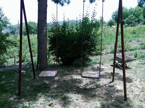 a swing in a yard next to a tree at Twins V.V.T Hostel in Orešani