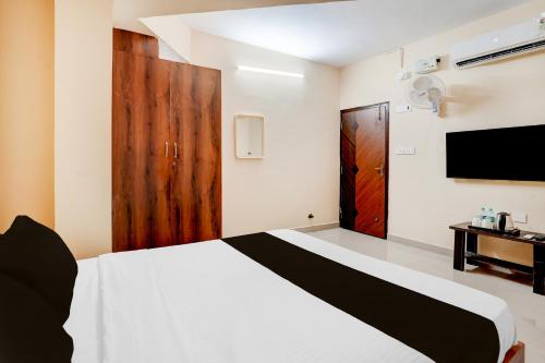 a bedroom with a white bed and a tv at Collection O Abbigere MLV Grand in Jālahalli