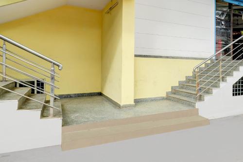 a staircase in a building with a yellow wall at Collection O Abbigere MLV Grand in Jālahalli