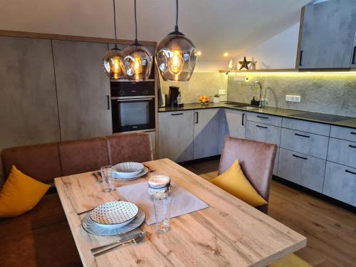 a kitchen with a wooden table with two plates on it at Landhaus KitzAlp (Alpenheim) in Brixen im Thale