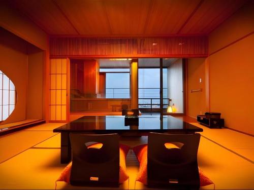a room with a table and chairs in a room at Kannawa Onsen Hotel Sansuikan in Beppu