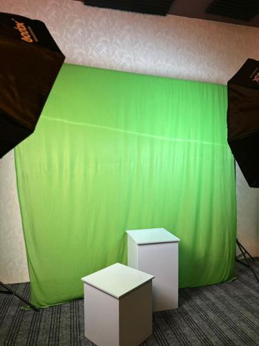 Una pared verde con dos mesas en una habitación. en Intelzaa Studio, 