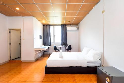 a bedroom with a bed and a desk in it at At Gate Suvarnabhumi-สุขุมวิท 77 in Lat Krabang