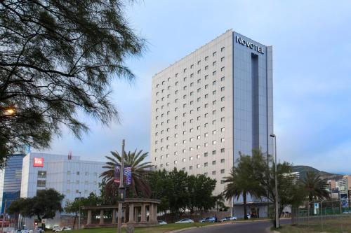 a tall white building with a sign on it at Novotel Monterrey Valle in Monterrey