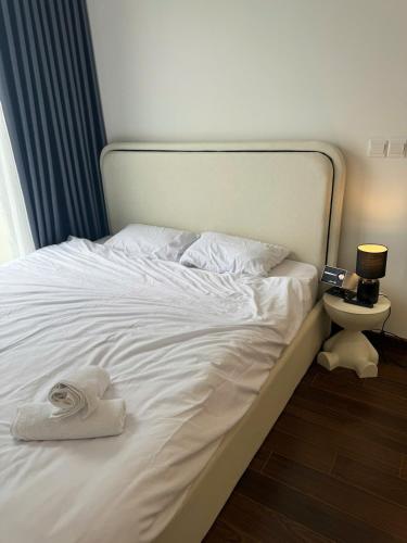 a white bed with a pile of towels on it at Mas D3208 in Phú Thú