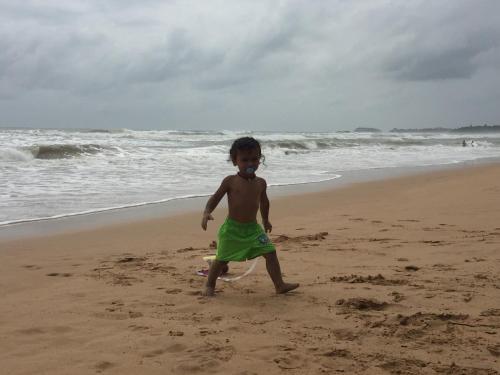 a young child walking on the beach at Solal Villa in Aluthgama