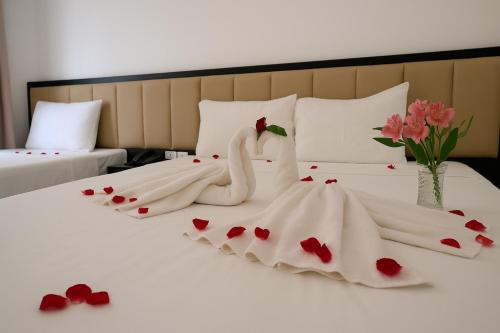 two swans in a wedding dress sitting on a bed at Euphoria Hotel & Spa in Hanoi