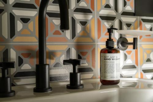 a bottle of alcohol sitting on a bathroom sink at Mode Eco Mood Hotel - Adults Friendly in Rimini