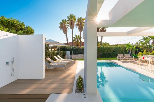 a house with a swimming pool and palm trees at Gadir in Terrauzza