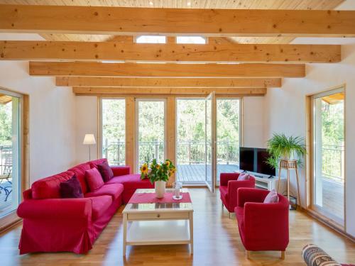 a living room with a red couch and red chairs at Riverside Stay in Sudwinsen in Winsen Aller